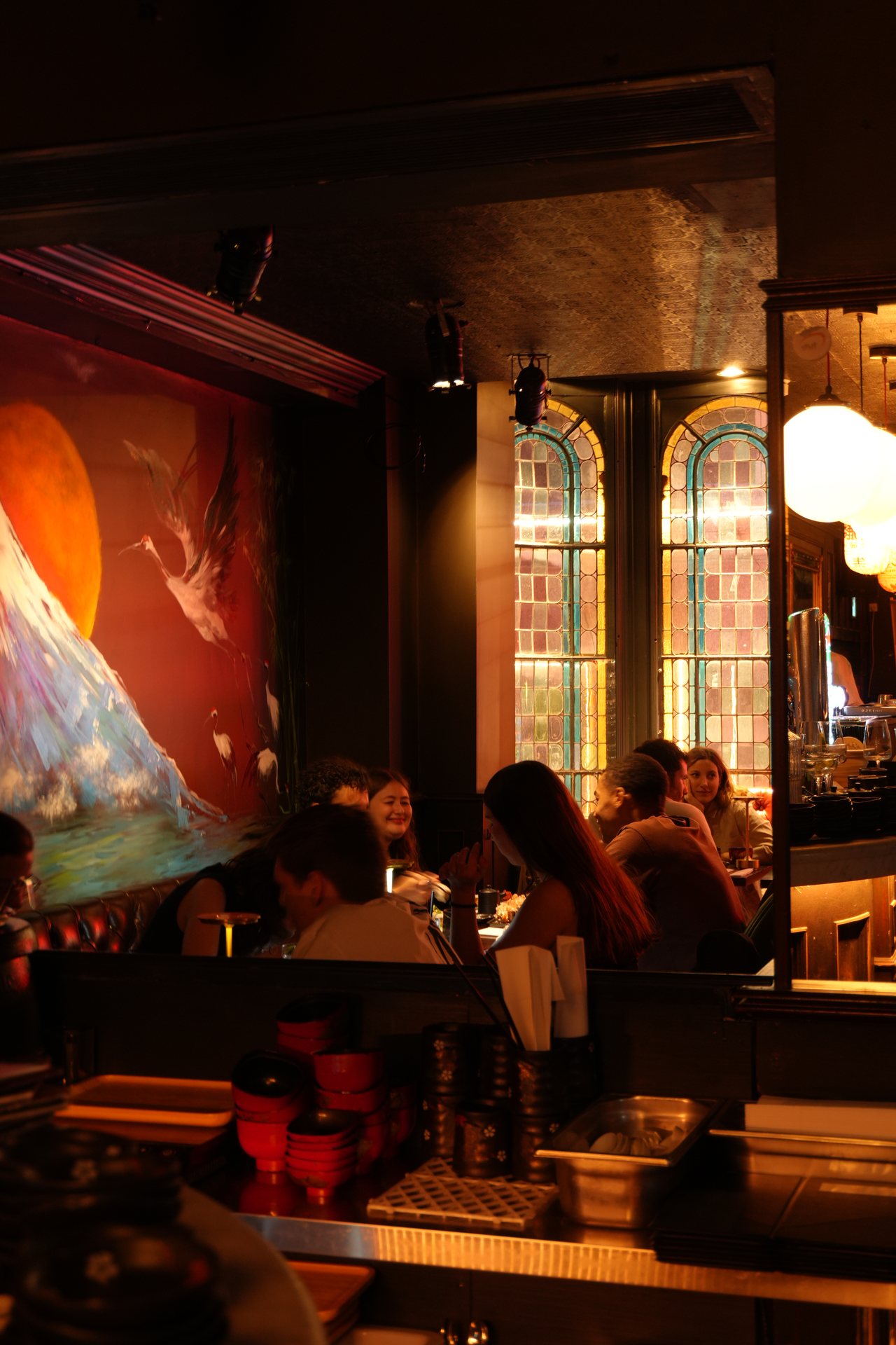 Guests at Kyodai Dame Street upstairs, beside the stained-glass windows